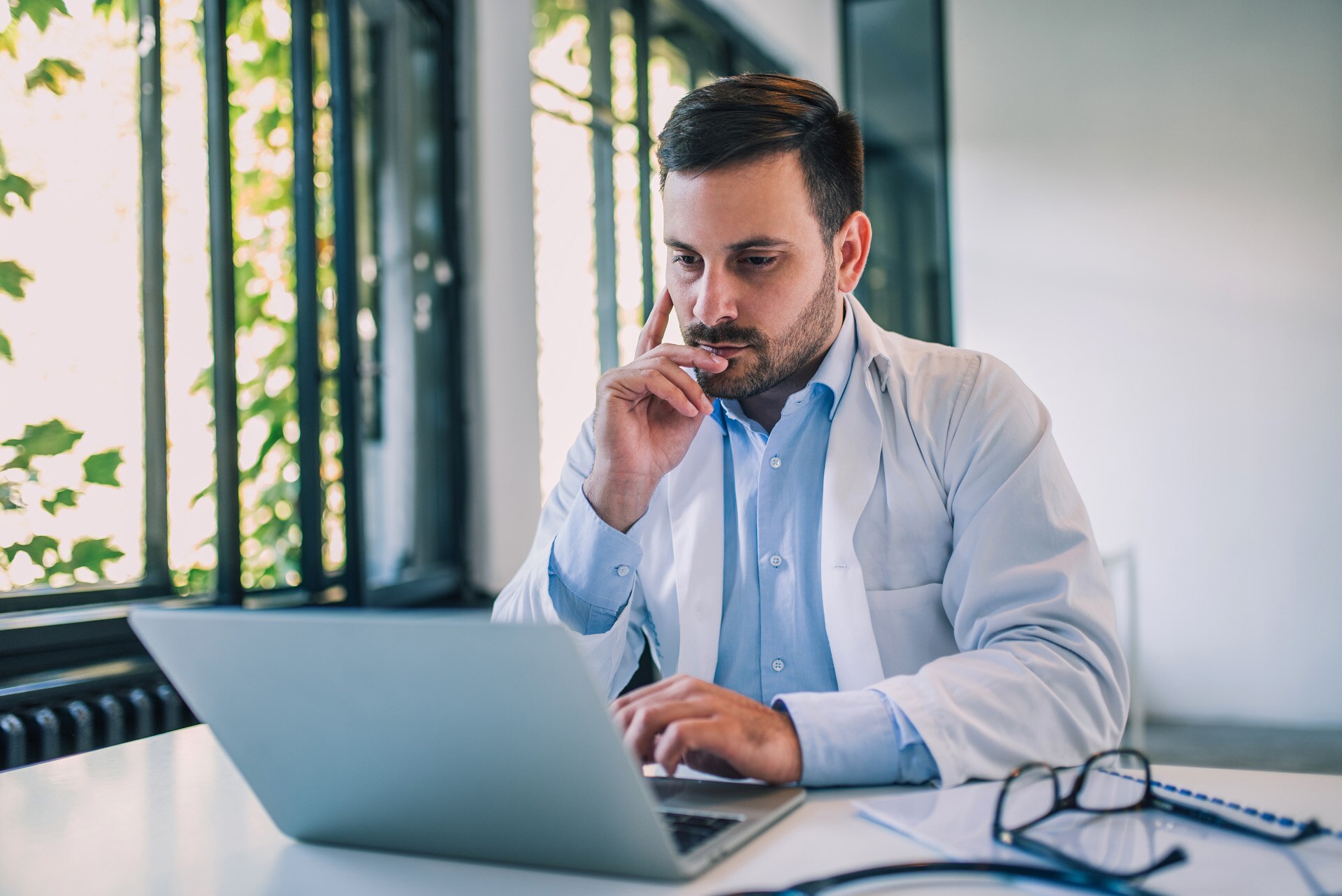 A doctor reviewing something on a laptop