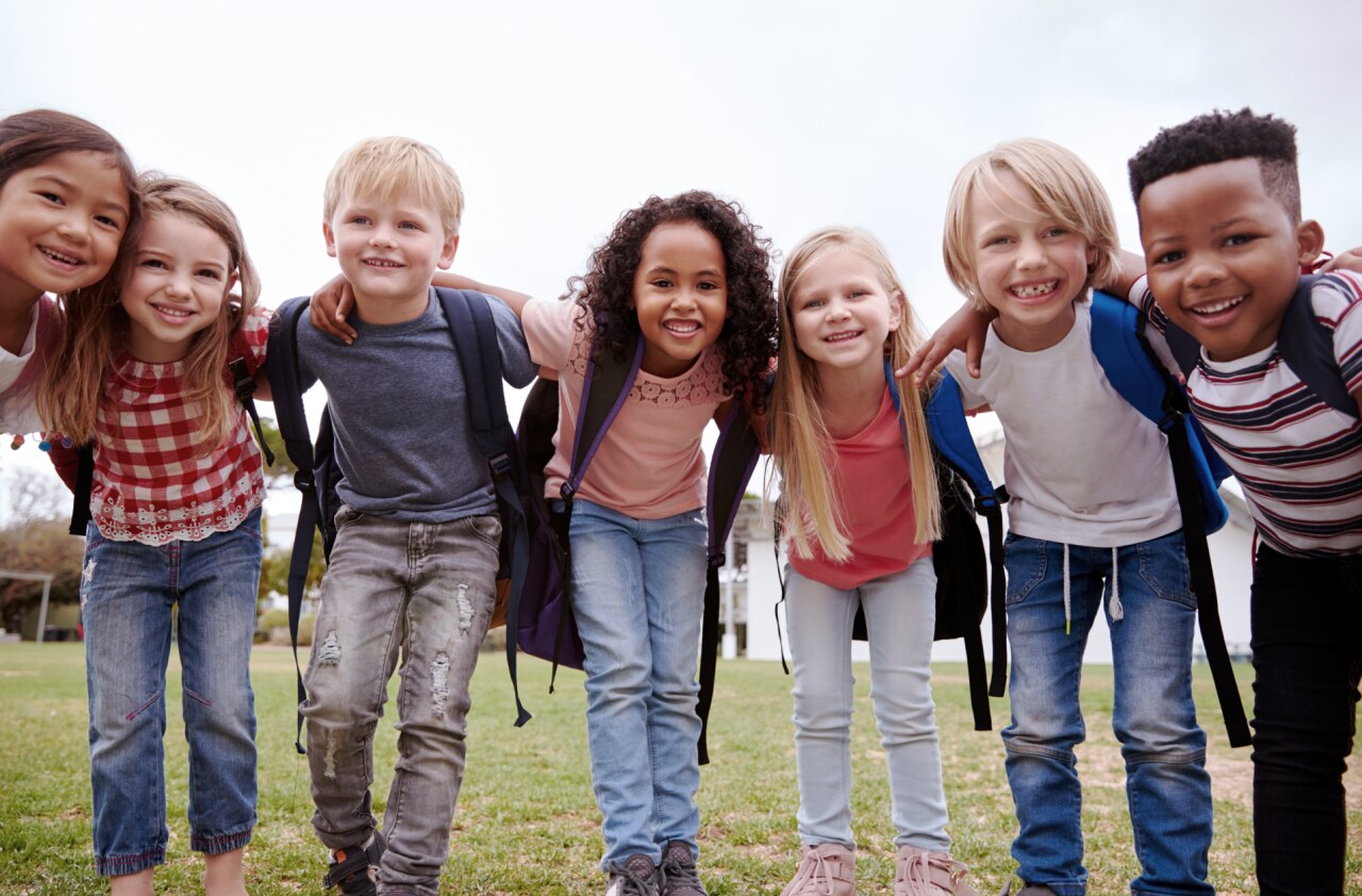 Portrait Of Excited Elementary School Pupils On Playing Field At Break Time