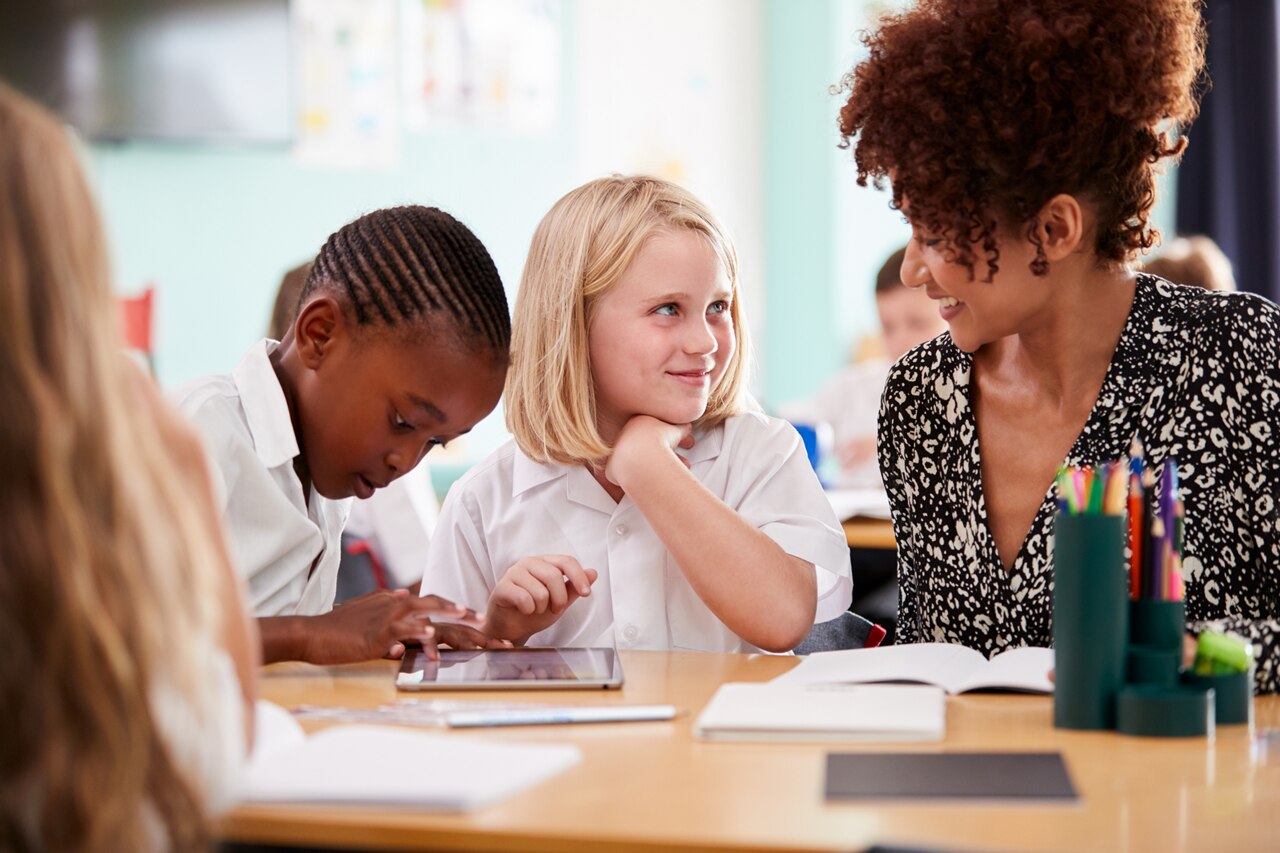 A female teacher talking to two pupils