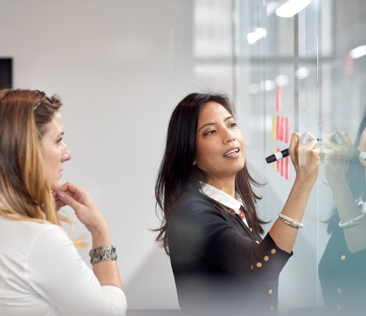 Businesswoman looking at female colleague presenting some ideas in the office.
